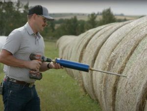beef cattle producer feed sampling a round hay bale